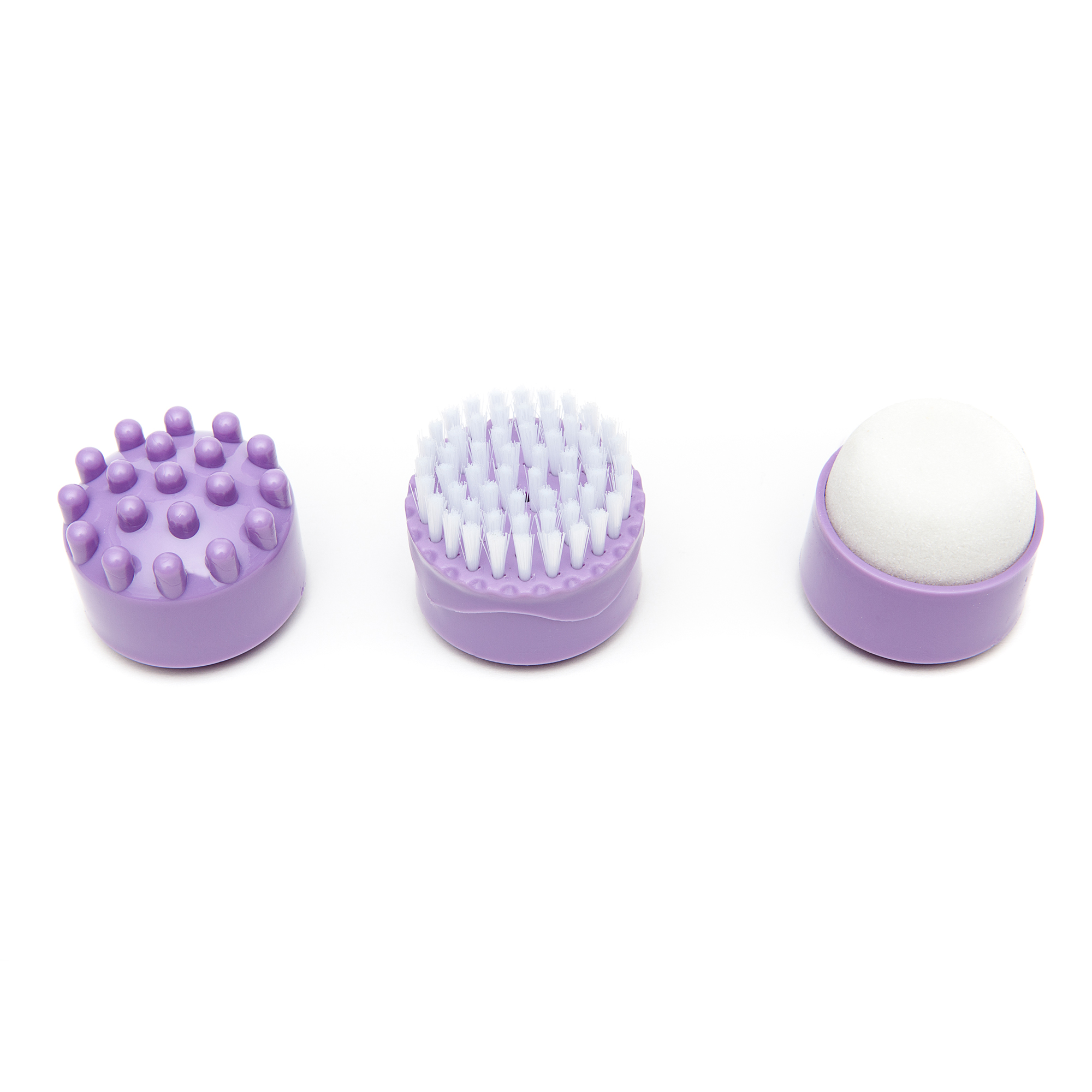 Tre accessori per la pulizia del viso viola. Testine massaggianti, spazzola e spugna su bianco.