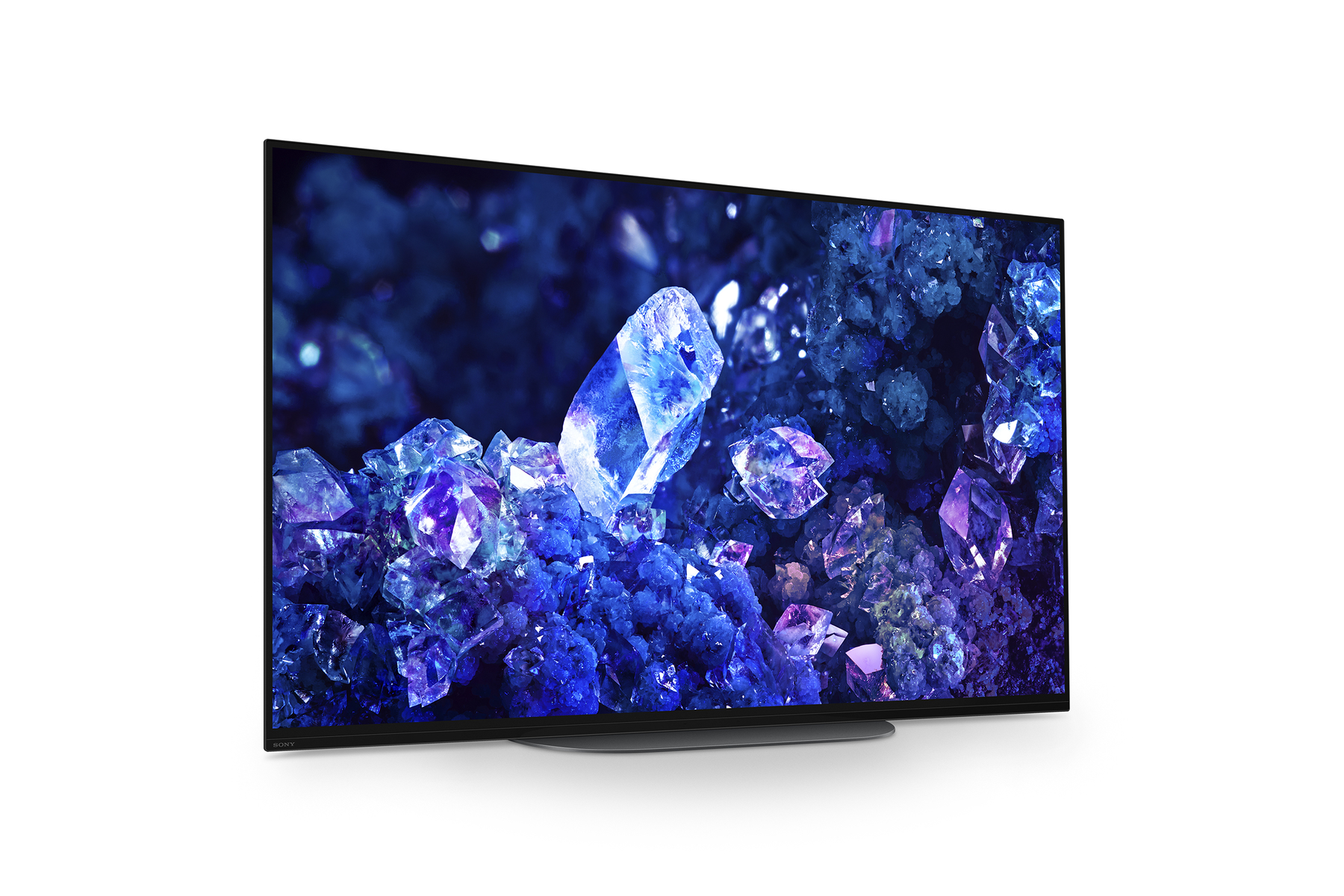 Una grande TV Sony che mostra un'immagine blu scuro, viola e bianca di una formazione cristallina.