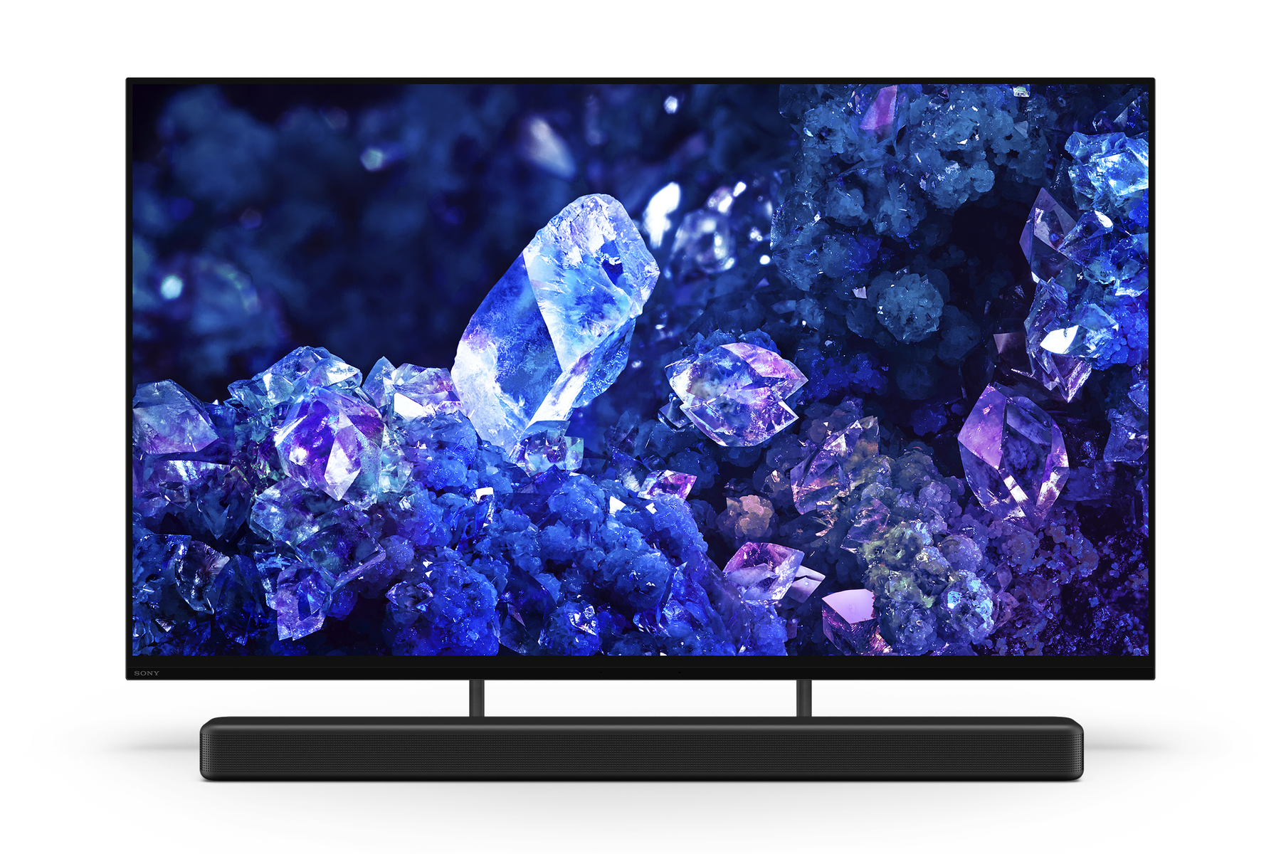 Una TV moderna con una vibrante scena di cristalli blu e viola e una soundbar nera sotto.