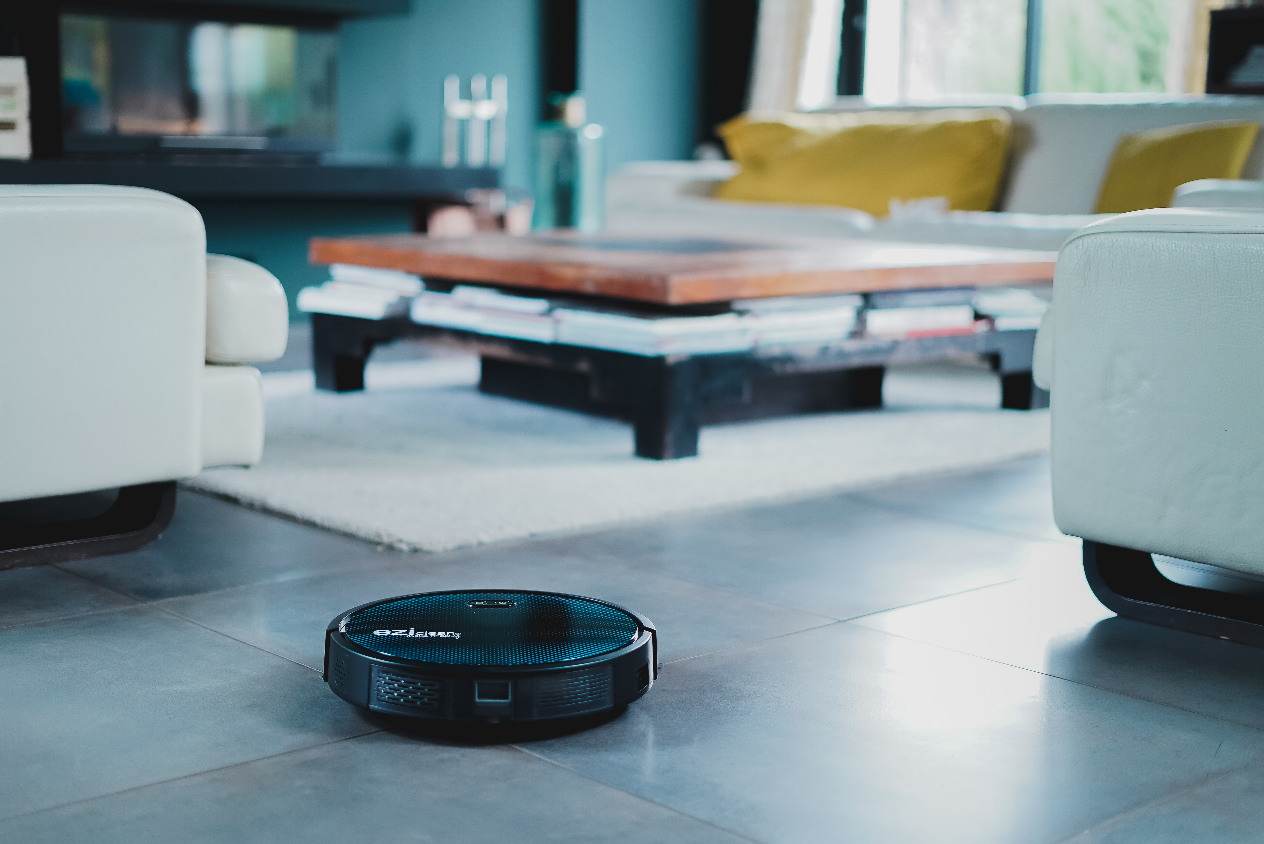Una aspiradora robot en un suelo de baldosas en una sala de estar.