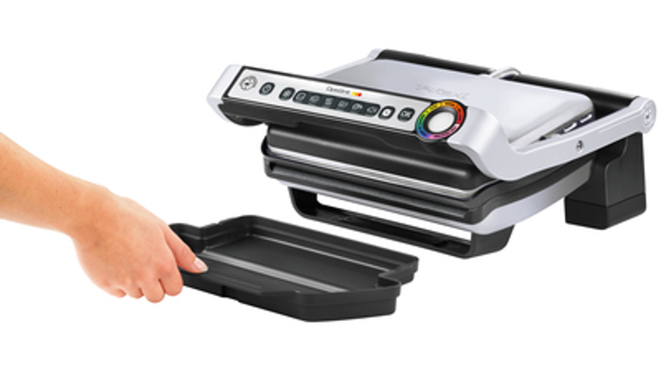 Un electrodoméstico de cocina, una plancha para panini, con una bandeja que se retira con una mano. Fondo blanco.