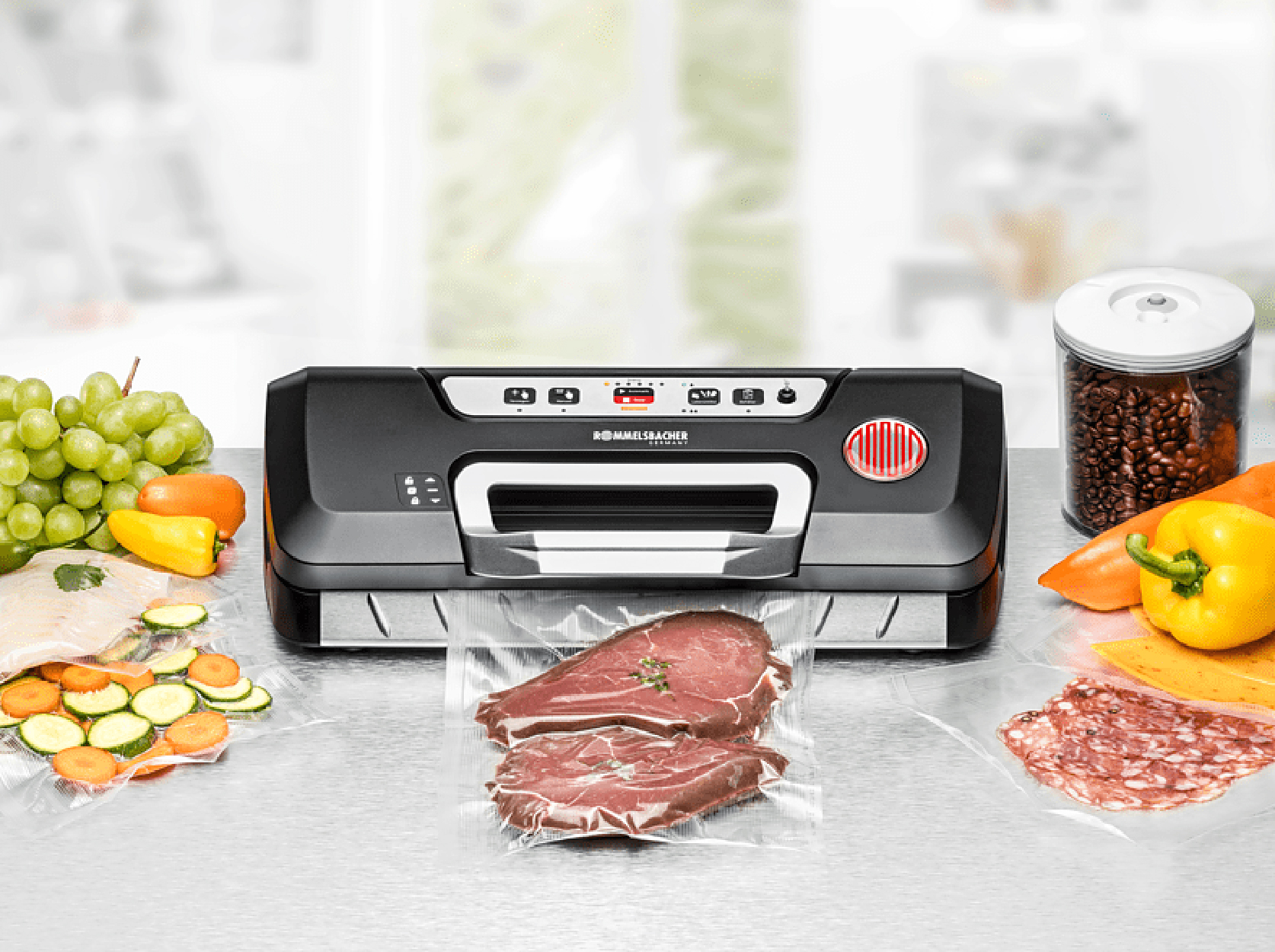 Zgrzewarka próżniowa z produktami spożywczymi: stek, warzywa, ser, winogrona i ziarna kawy.