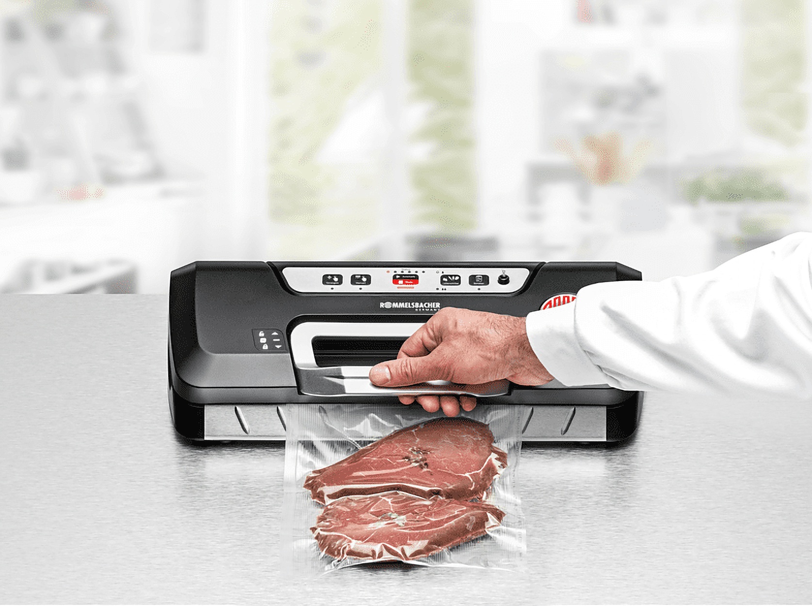 Osoba używająca zgrzewarki próżniowej Rommelsbacher. Dwa kawałki mięsa w przezroczystej torbie.