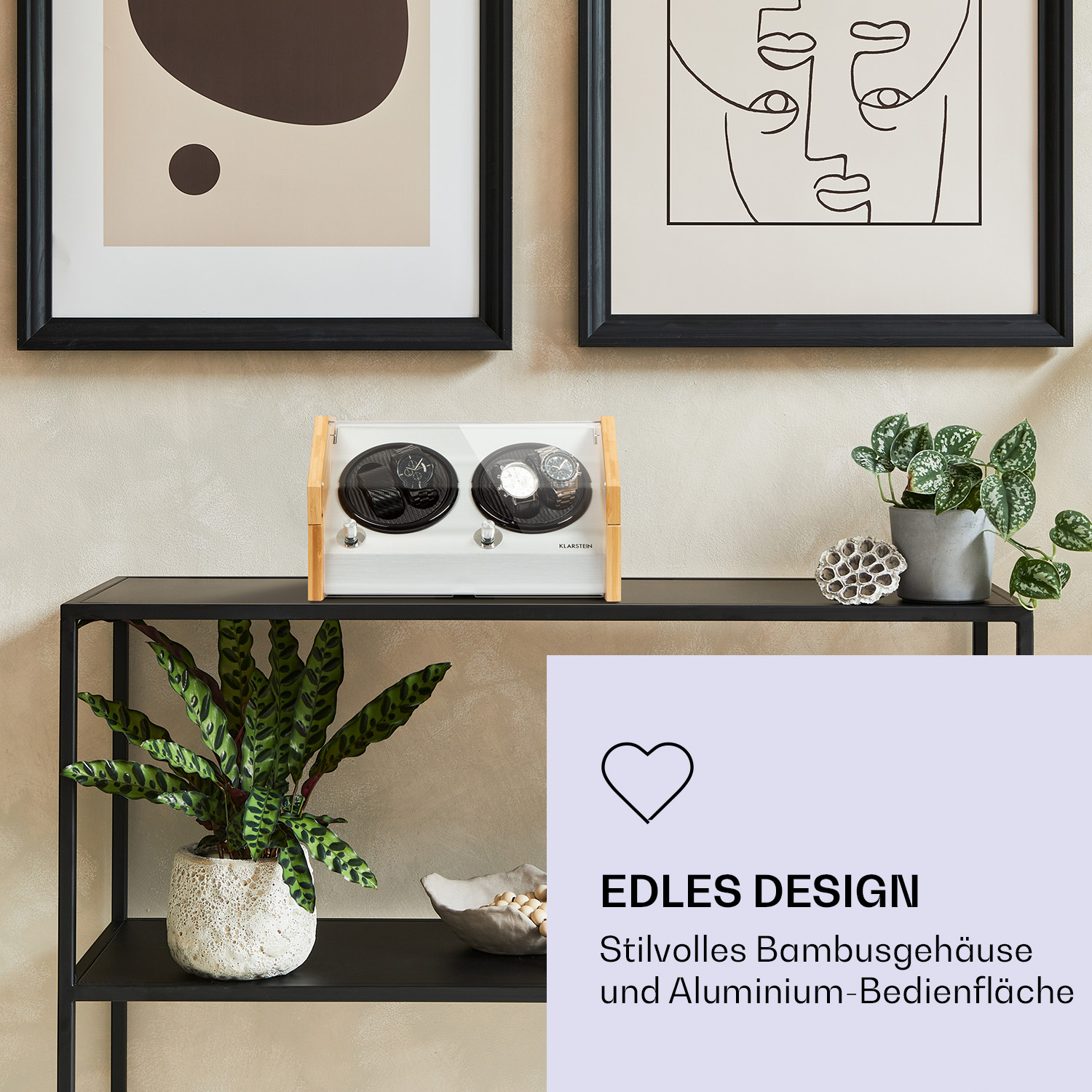 Zwei gerahmte Bilder und ein Uhrenbeweger auf einem schwarzen Regal mit Pflanzen. Der Text lautet: Edles Design und Alu-Oberfläche.