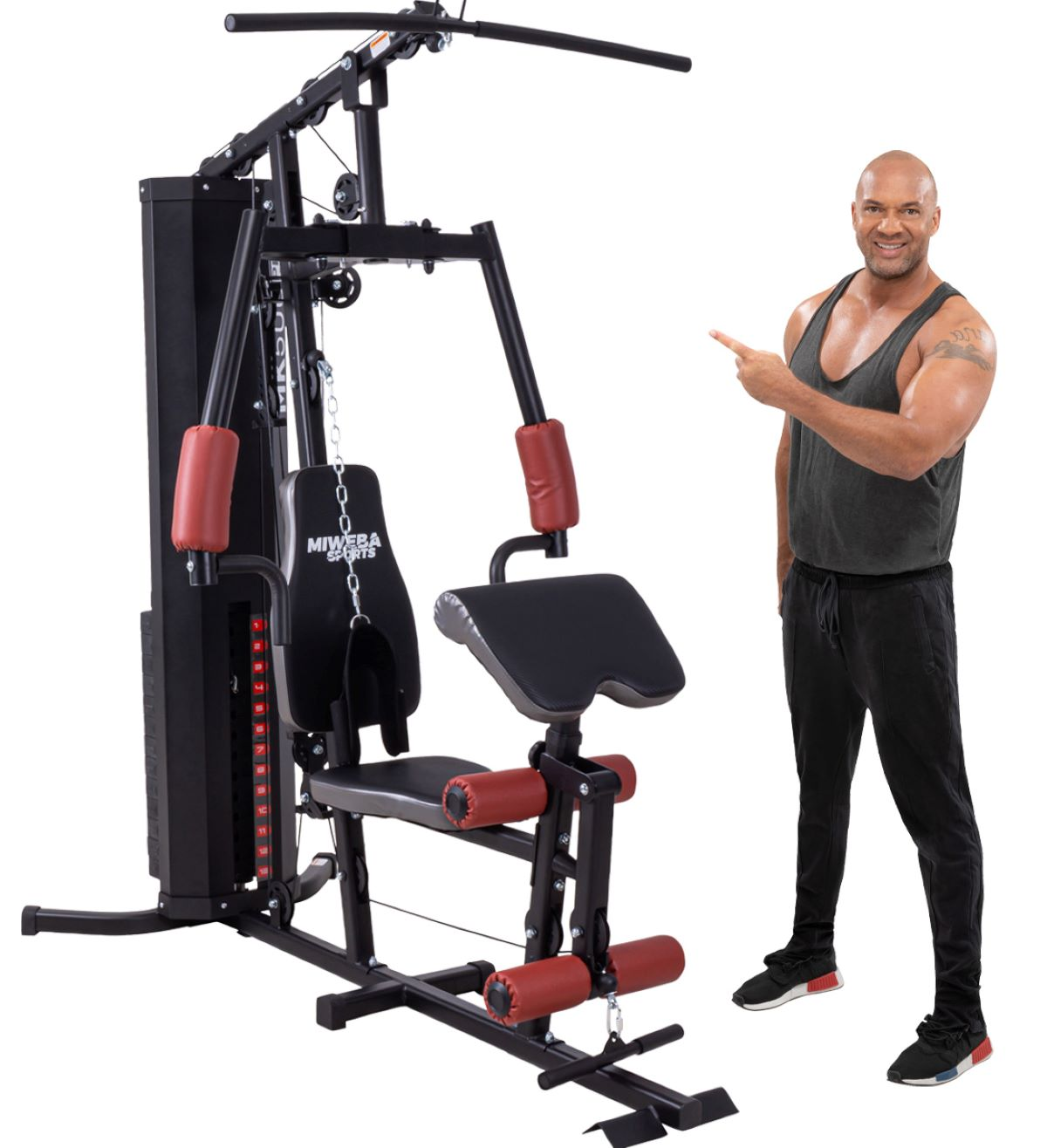 Ein Mann zeigt auf eine Heimfitnessmaschine. Die Maschine ist schwarz und rot. Weißer Hintergrund.