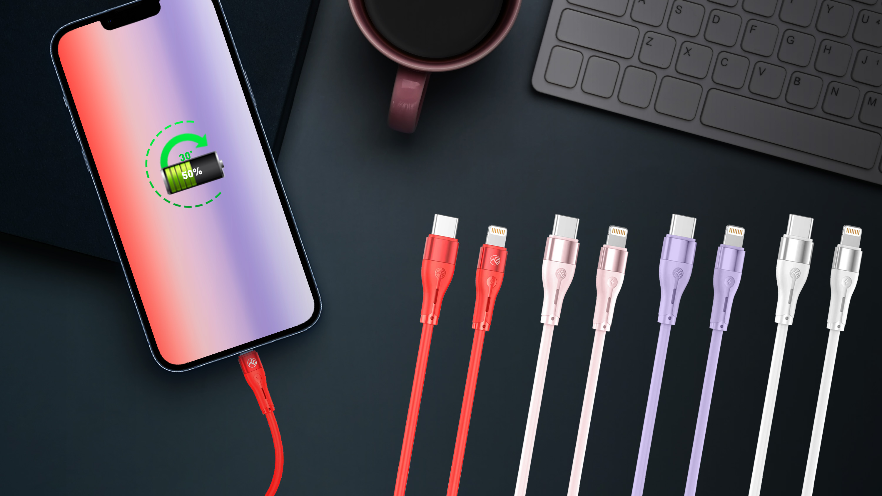 Telefon ładujący się czerwonym kablem. Obok znajduje się kilka kolorowych kabli do ładowania.