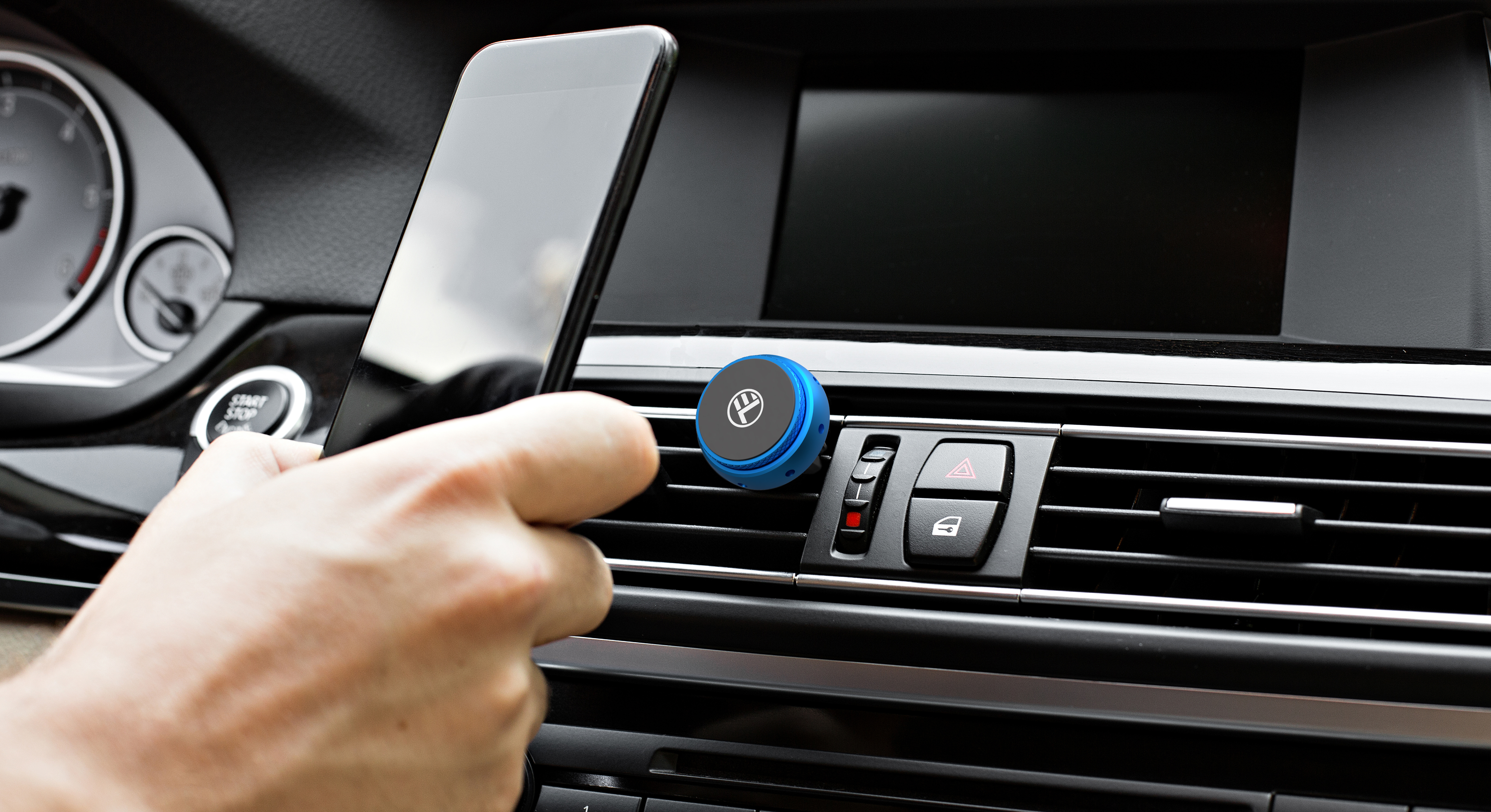 Dłoń trzyma telefon blisko kratki, niebieski uchwyt magnetyczny.