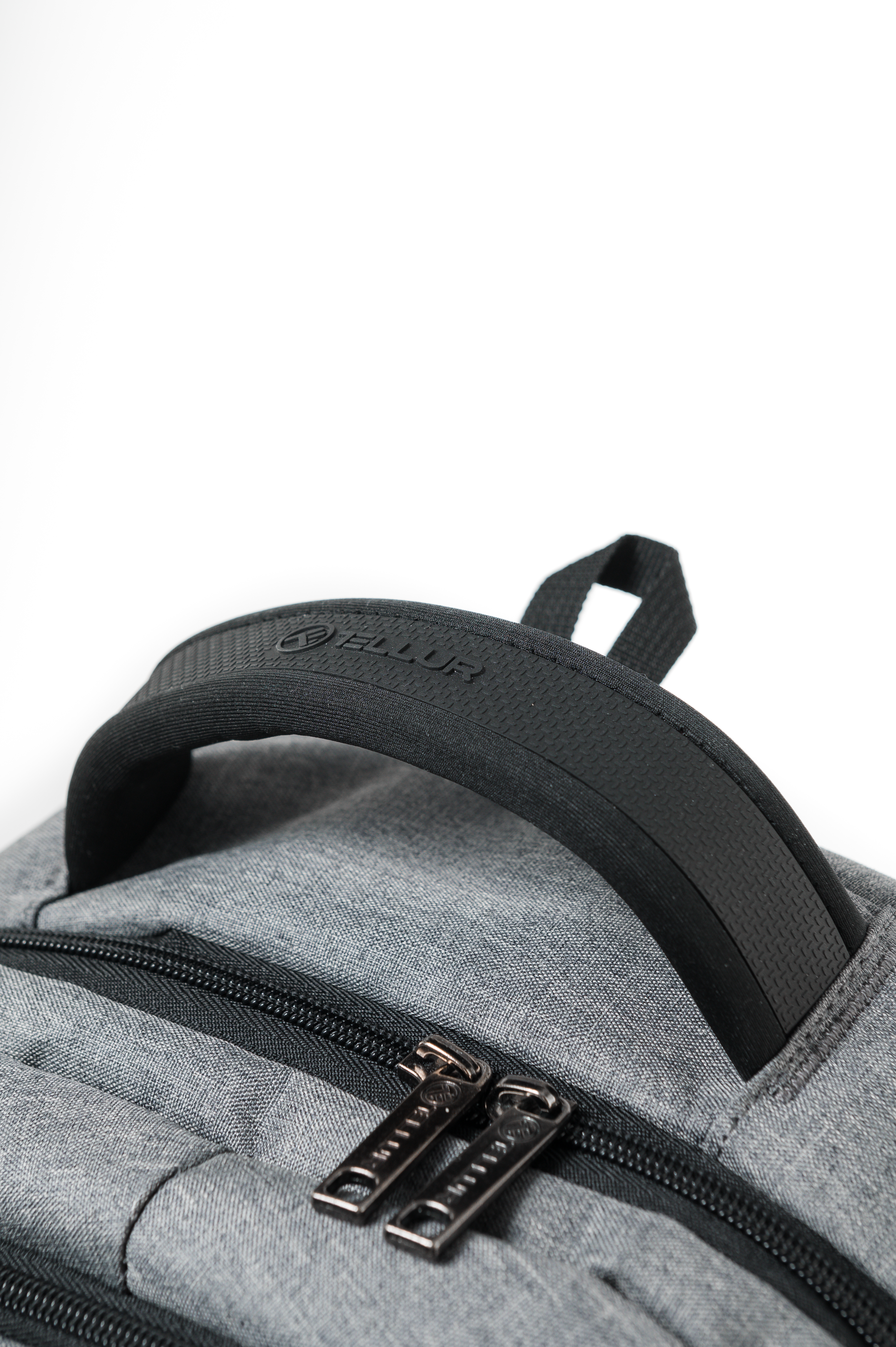 Zbliżenie szarego plecaka z czarnym uchwytem i zamkami. Uchwyt ma logo Ellur.