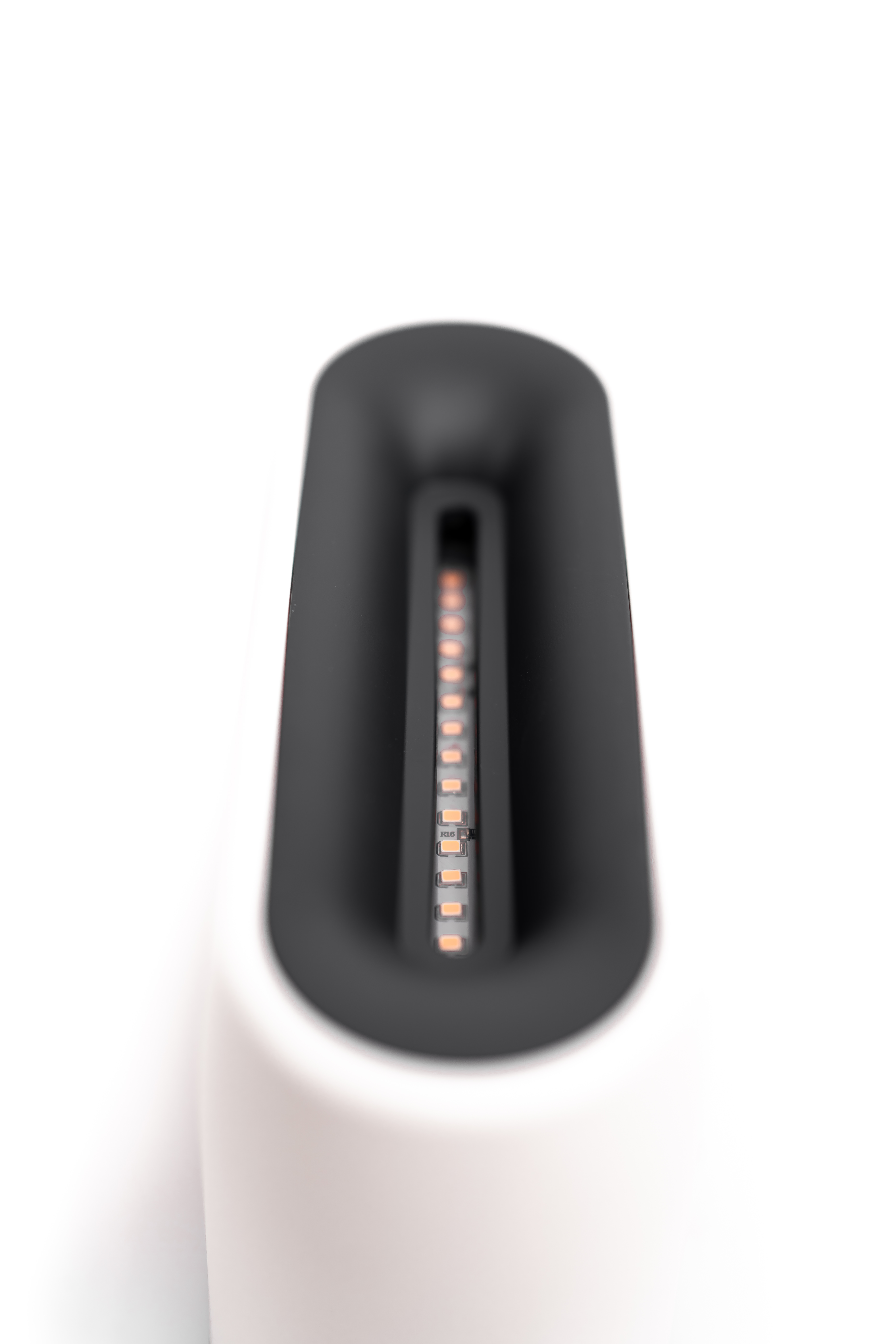 Zbliżenie portu ładowania. Jest biały z czarną górą i pomarańczowymi światłami.