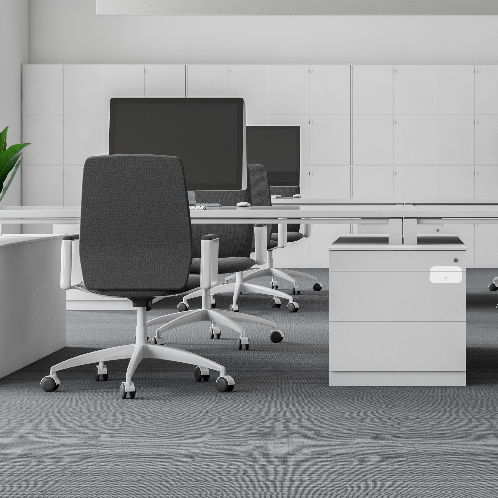 Büro mit Schreibtischen, Stühlen und Computern. Weiße Schränke säumen die Rückwand, grauer Teppich.