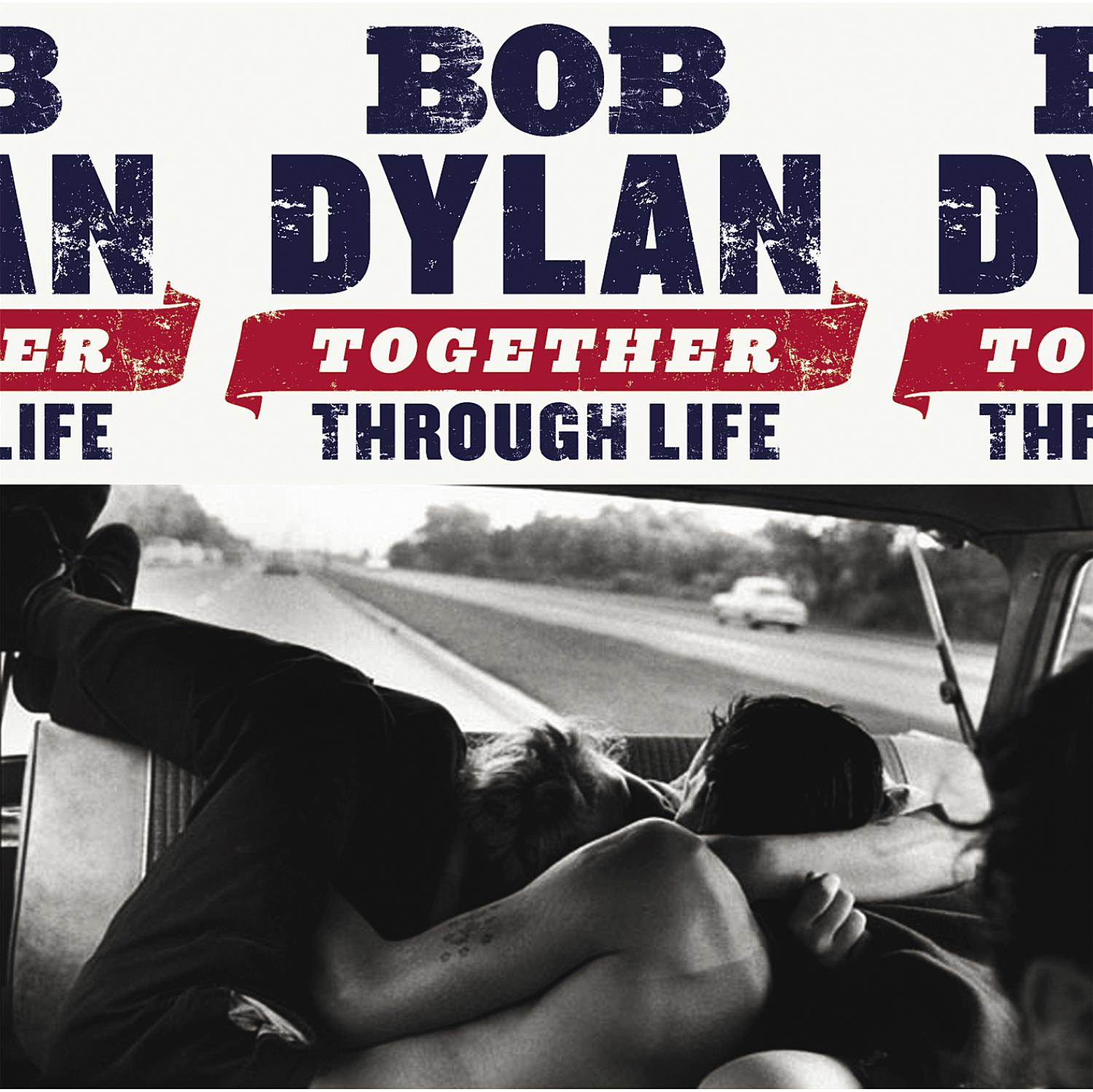Schwarz-Weiß-Albumcover: Bob Dylans Name steht oben. Menschen sitzen im Auto, Beine hoch, Hände haltend.