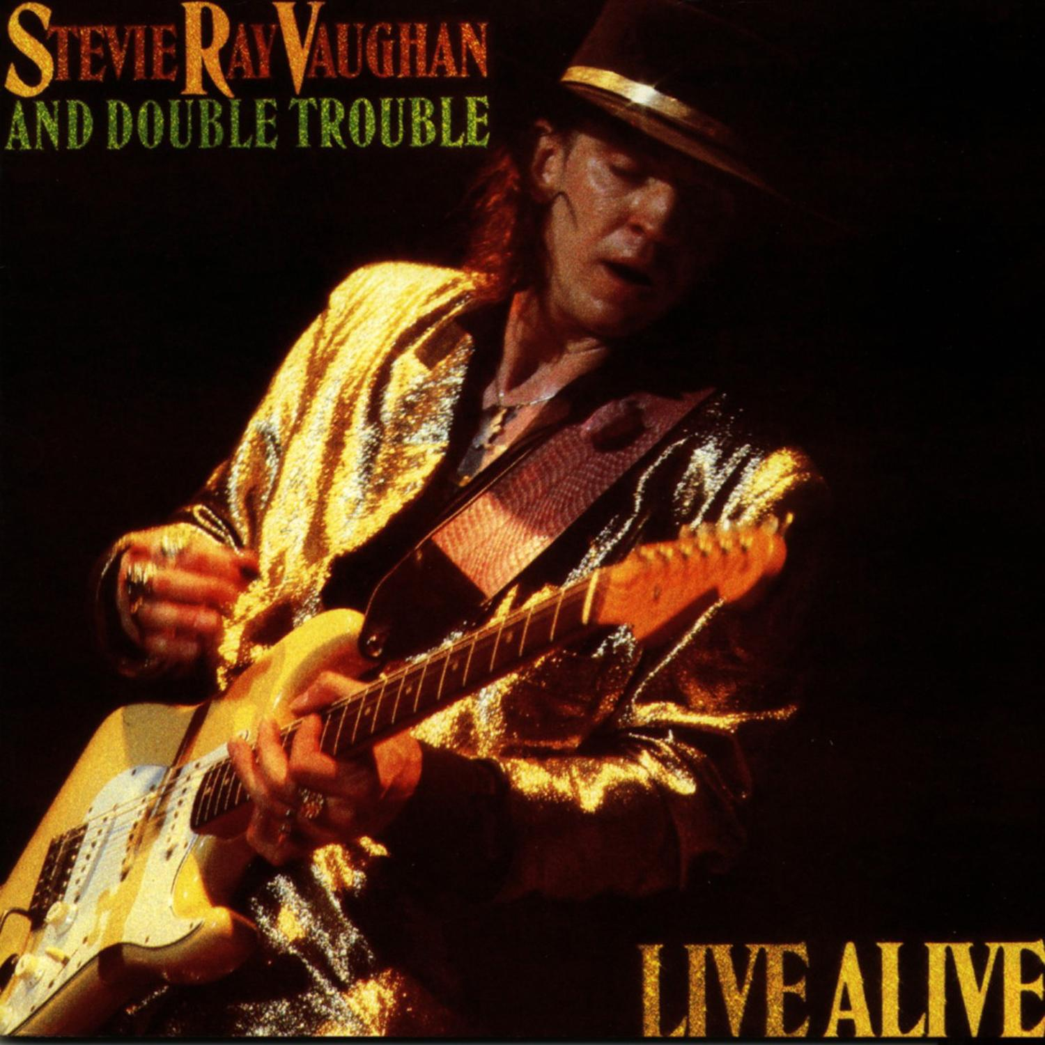 Stevie Ray Vaughan spielt Gitarre auf der Bühne. Das Albumcover lautet 'Live Alive'.