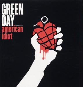Albumcover: Hand hält rote Herzgranate mit Blut, über schwarzem Hintergrund. 'American Idiot'.