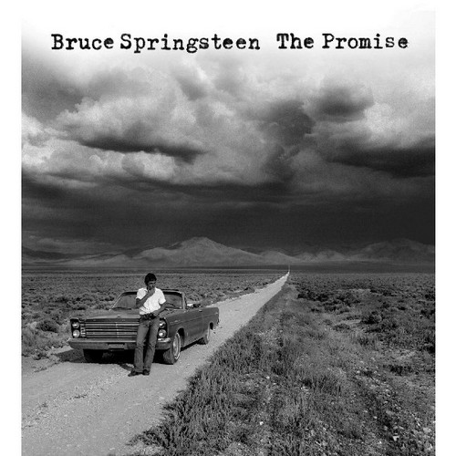 Bruce Springsteen Albumcover: Schwarz-Weiß-Foto von Mann und Auto auf einer Wüstenstraße unter stürmischem Himmel.