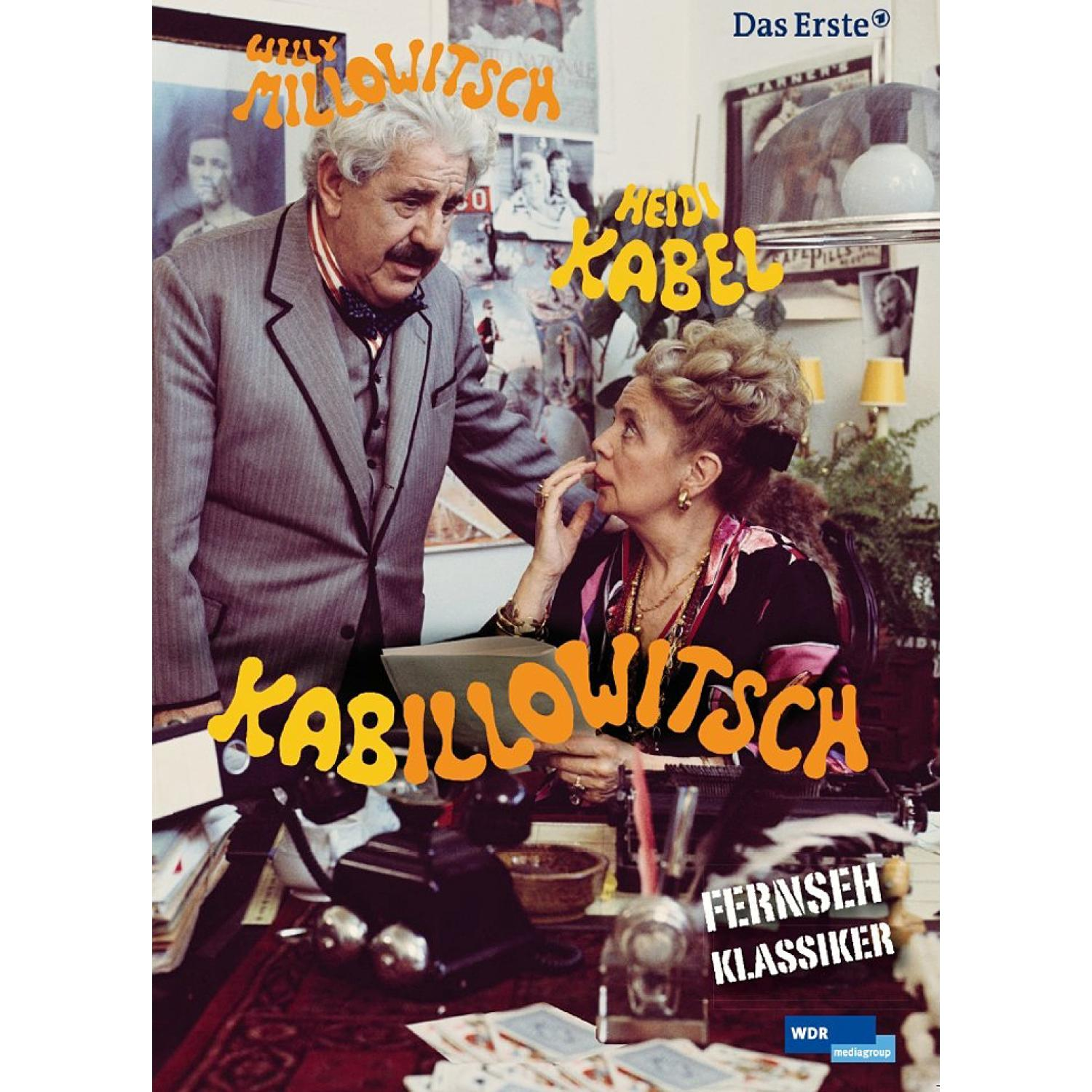 Ein Mann und eine Frau stehen an einem Schreibtisch, die Frau berührt ihr Gesicht. Text-Overlay zeigt Kabarettnamen.