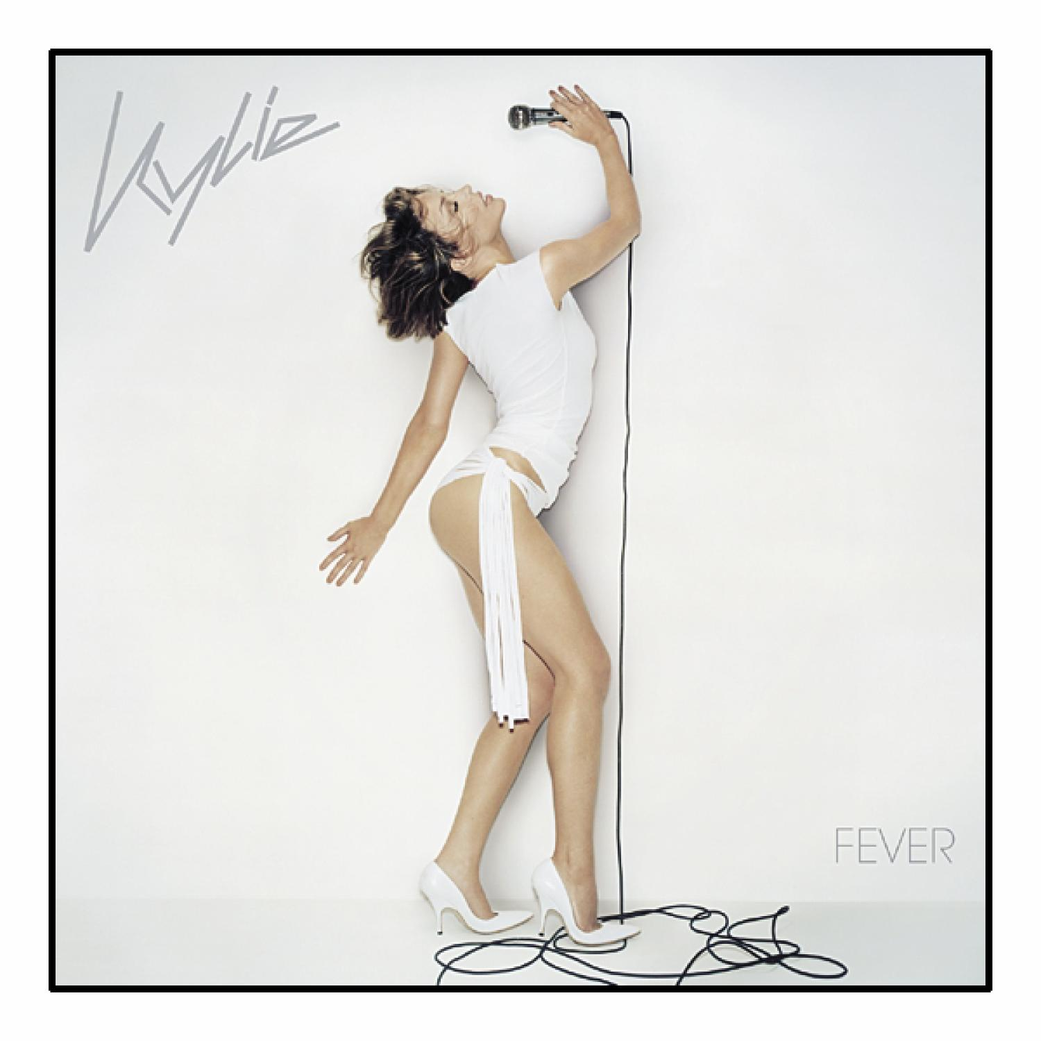 Kylie Albumcover, Frau mit weißem Outfit, weißen Absätzen, hält ein Mikrofon, weißer Hintergrund.