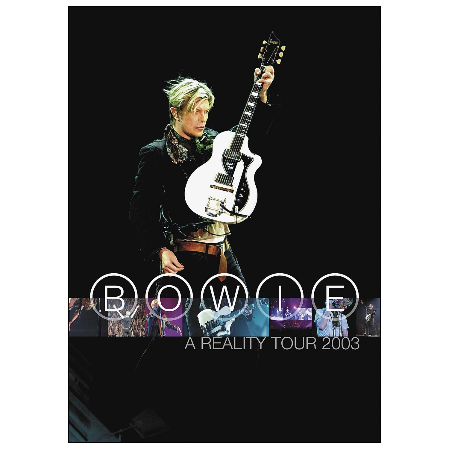 David Bowie auf der Bühne mit einer weißen Gitarre, Bühnenlicht und dem Text 'BOWIE A REALITY TOUR 2003'.