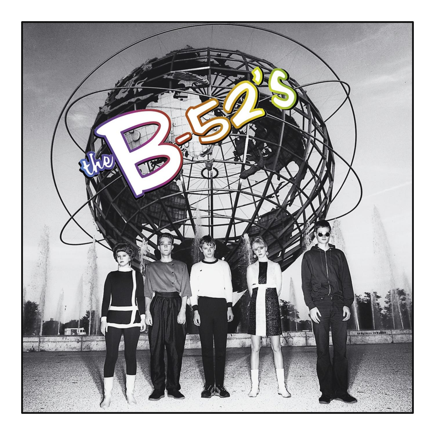 Die Band The B-52's steht vor einem Globus. Die Bandmitglieder stehen in einer Reihe.