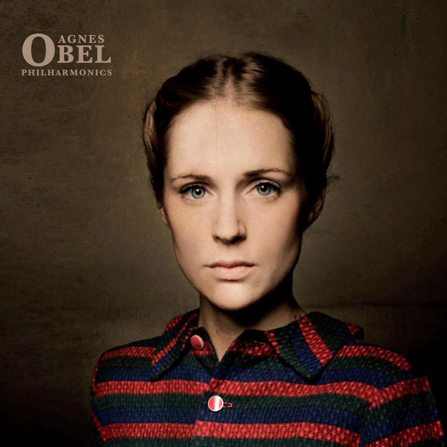 Agnes Obel Albumcover. Eine Frau mit ernstem Gesichtsausdruck. Sie trägt ein gestreiftes Hemd.