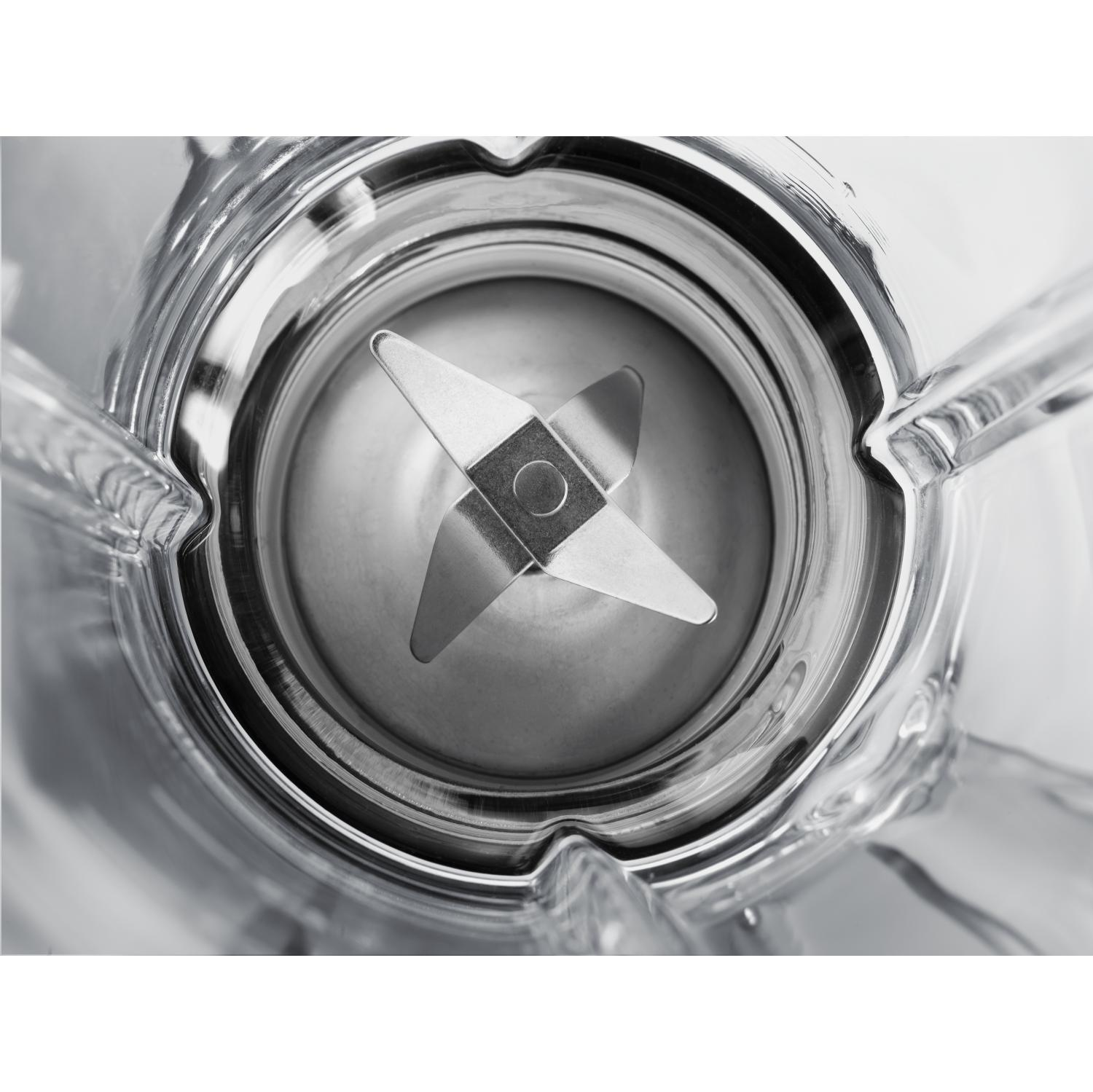 Zbliżenie ostrzy blendera w szklanym pojemniku. Ostrza są srebrne.