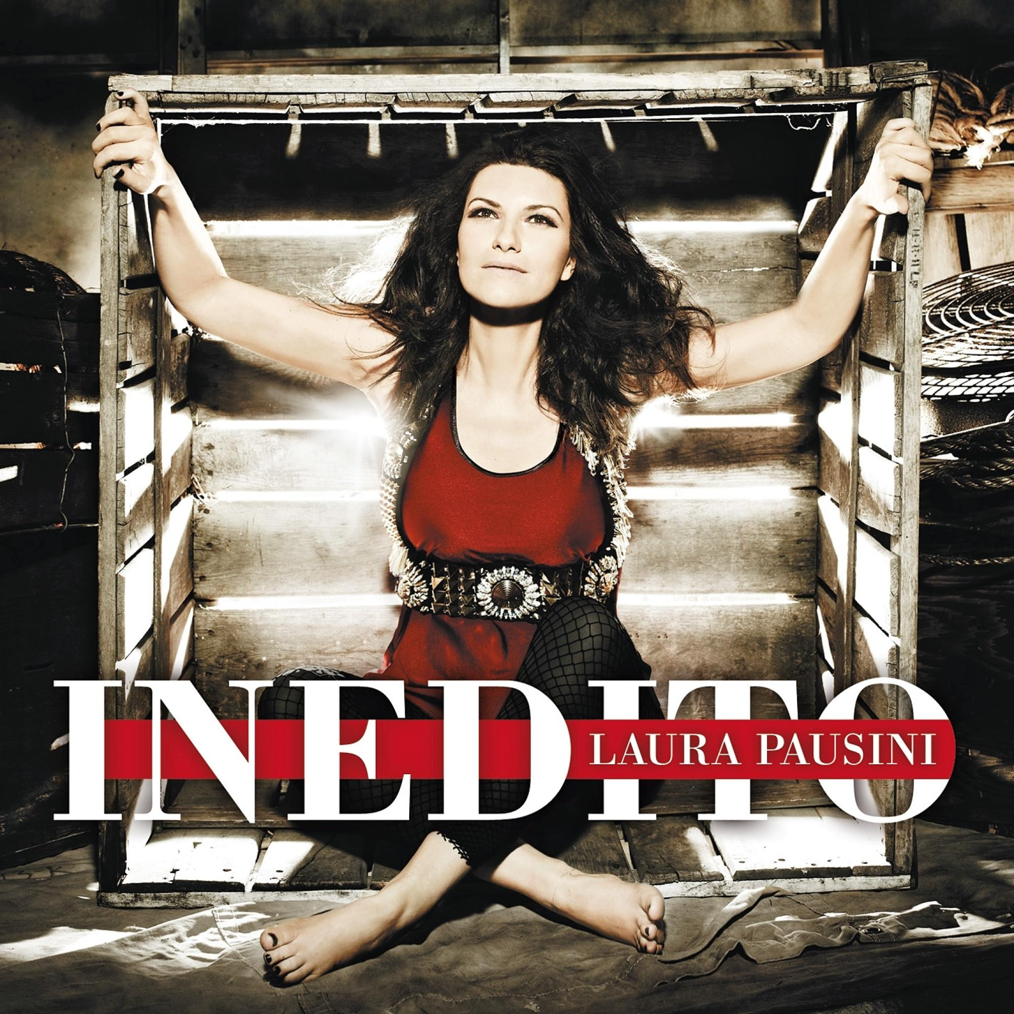Albumcover mit einer Frau in einem Holzrahmen. Text: INEDITO LAURA PAUSINI. Sie trägt ein rotes Oberteil und schwarze Hose.