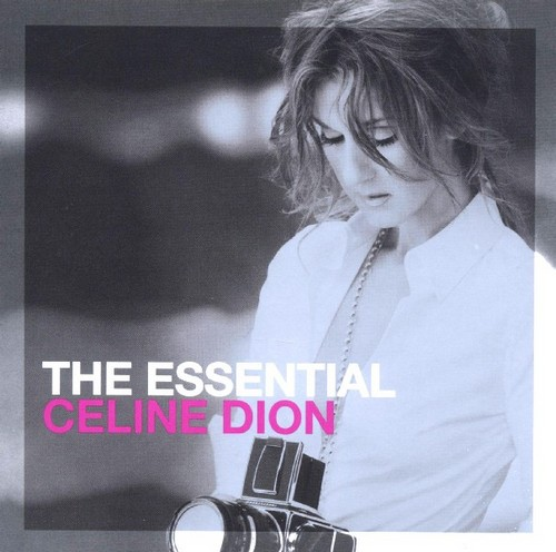 Albumhoes: Celine Dion, met een wit overhemd, houdt een camera vast. Titel: The Essential.