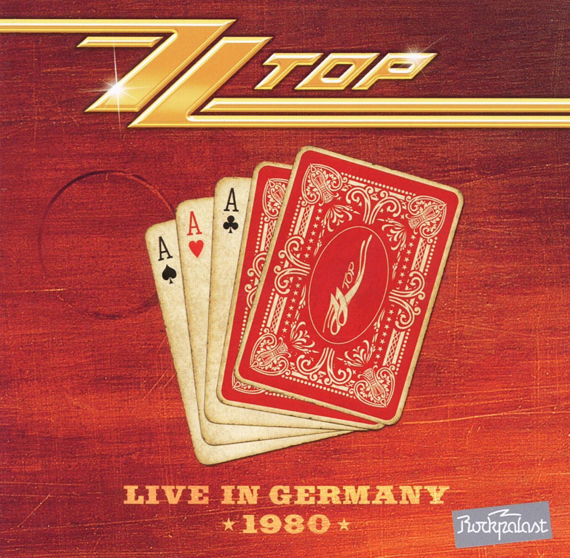 ZZ Top Albumcover mit Spielkarten auf rotem Holzmaserung Hintergrund.