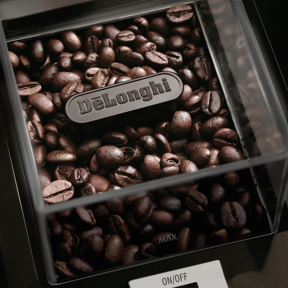 Kaffeebohnen in einem transparenten Behälter. DeLonghi-Logo oben. MAX-Pegel angegeben. Dunkler Hintergrund.