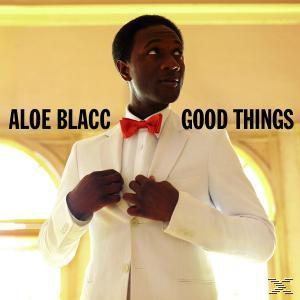 Aloe Blacc Albumcover. Ein Mann im weißen Anzug und roter Fliege, der zur Seite schaut.
