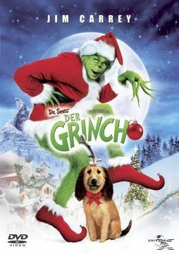 Der Grinch in Weihnachtskleidung hält eine Kugel, unten sitzt sein Hund Max mit Geweih vor schneebedeckter Kulisse.