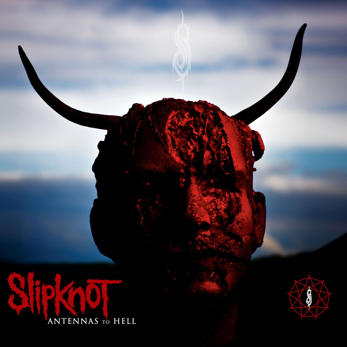 Slipknot-Albumcover. Ein rotes Gesicht mit Hörnern, ein weißes Logo und Text.