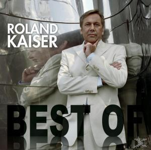 Roland Kaiser Albumcover. Kaiser in weißem Anzug, lehnt an einer silbernen, reflektierenden Oberfläche.