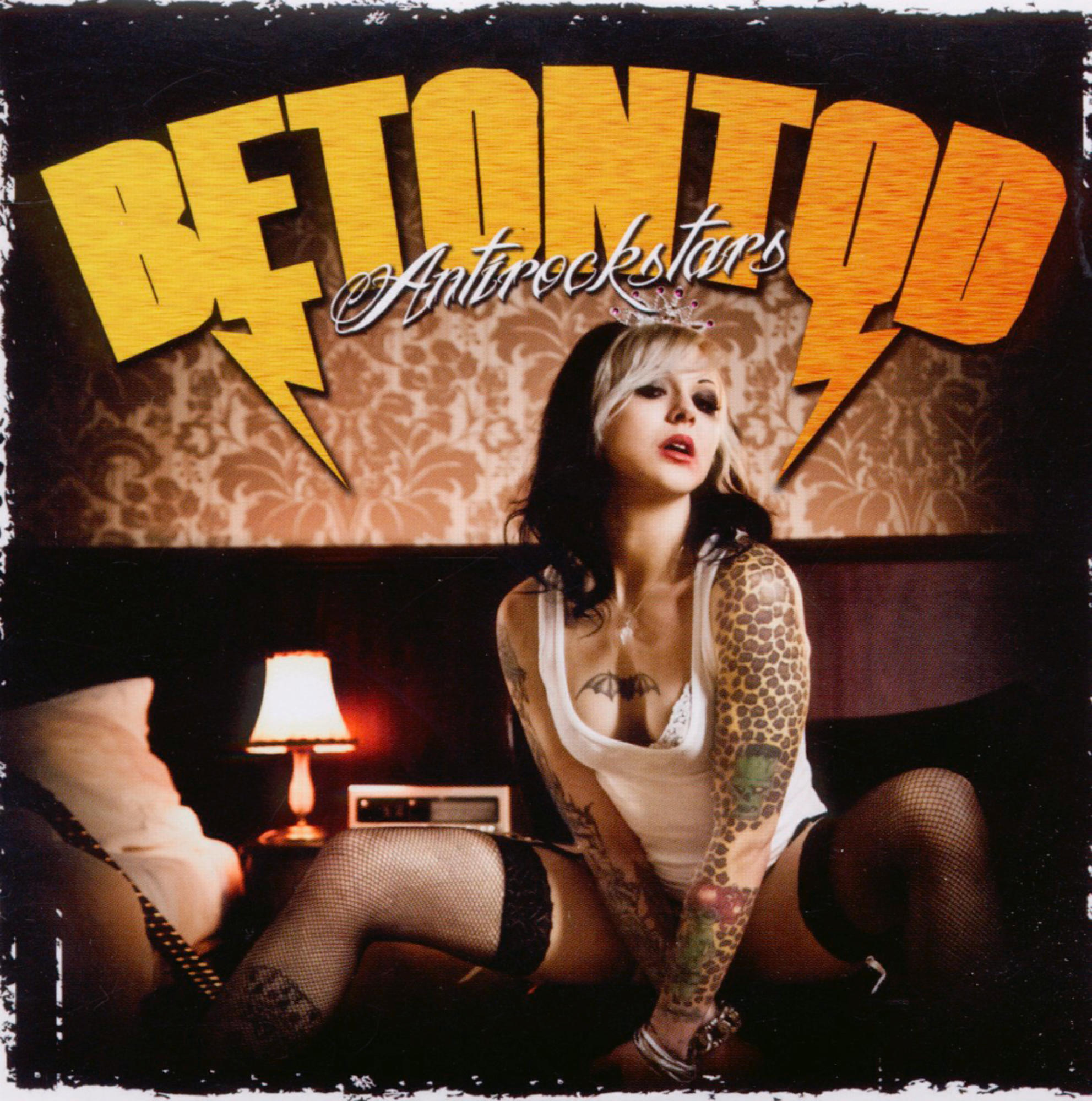 Albumcover. Betontod - Antirockstars. Eine Frau mit Tätowierungen und Krone sitzt auf einem Bett.