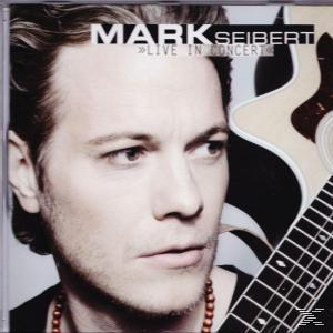 CD-Cover. Ein Mann, der zur Seite blickt, mit einer Gitarre hinter sich.