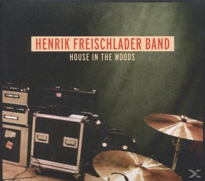 Albumcover mit Musikequipment und Text. Der Hintergrund ist dunkel.