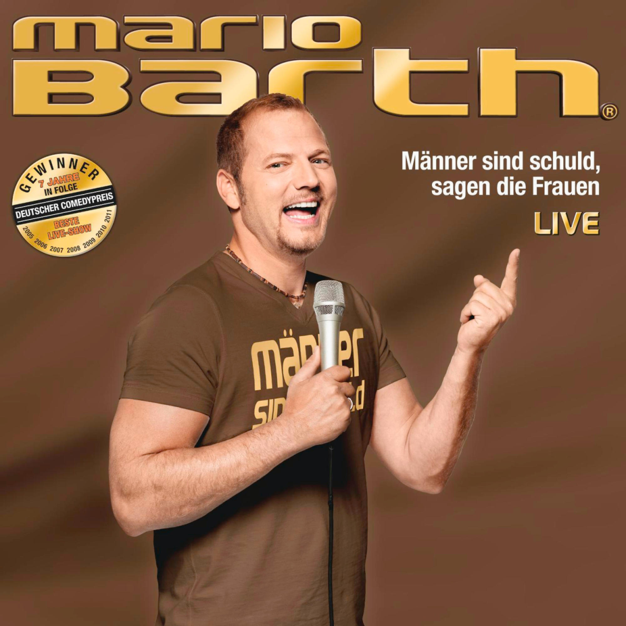 Ein Mann mit Mikrofon lächelt, hält ein Mikrofon und zeigt.