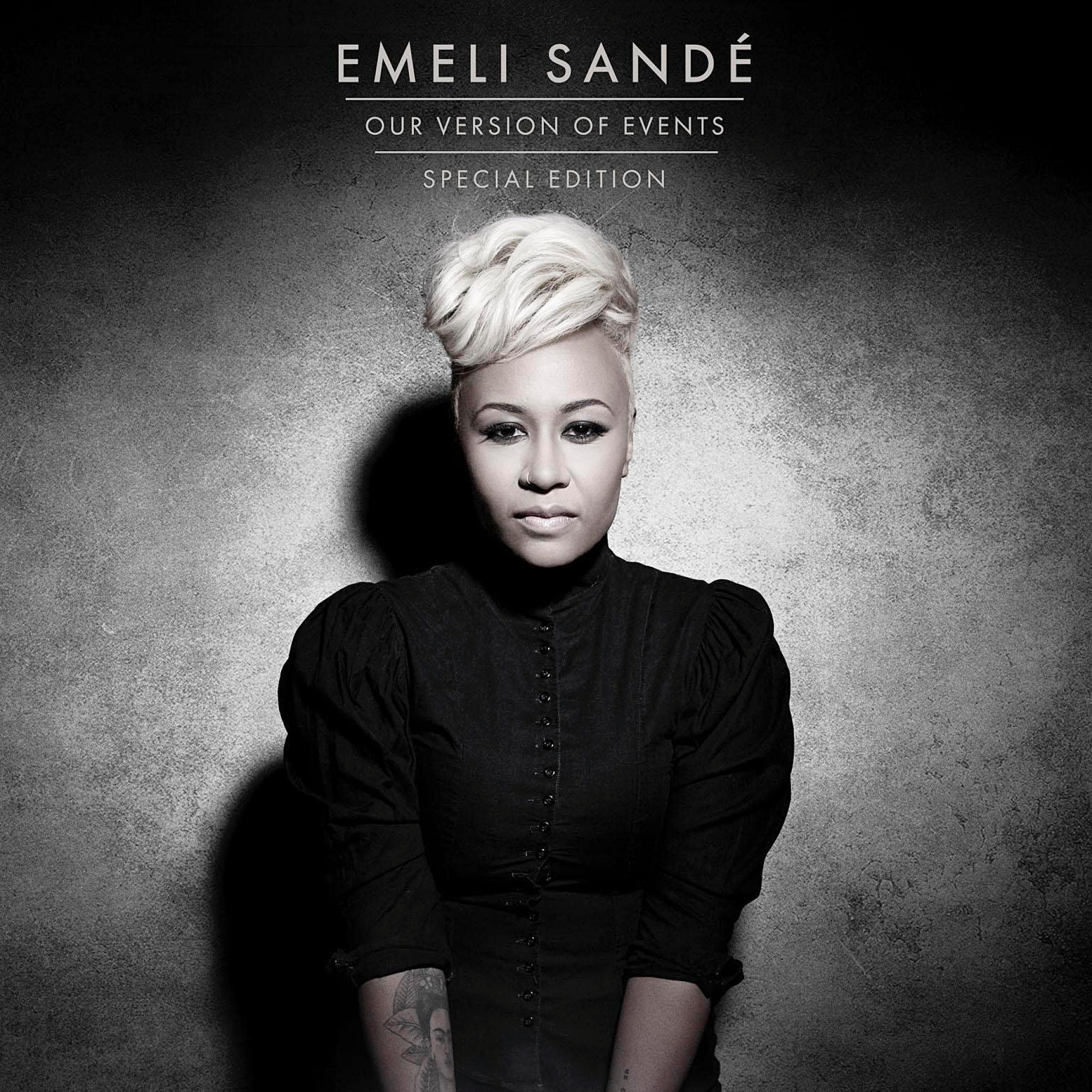 Emeli Sandé Albumcover, blickt in die Kamera, trägt ein schwarzes Kleid, mit grauem strukturierten Hintergrund.