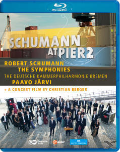 Blu-ray-Cover: 'Schumann at Pier 2'. Orchester, Boote und Text. Blaue Hülle, Konzertfilm.