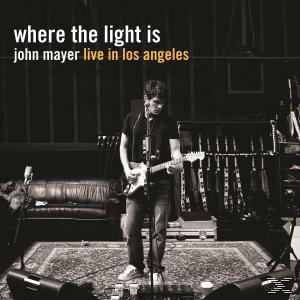 John Mayer a színpadon, gitározik, sötét háttér előtt.