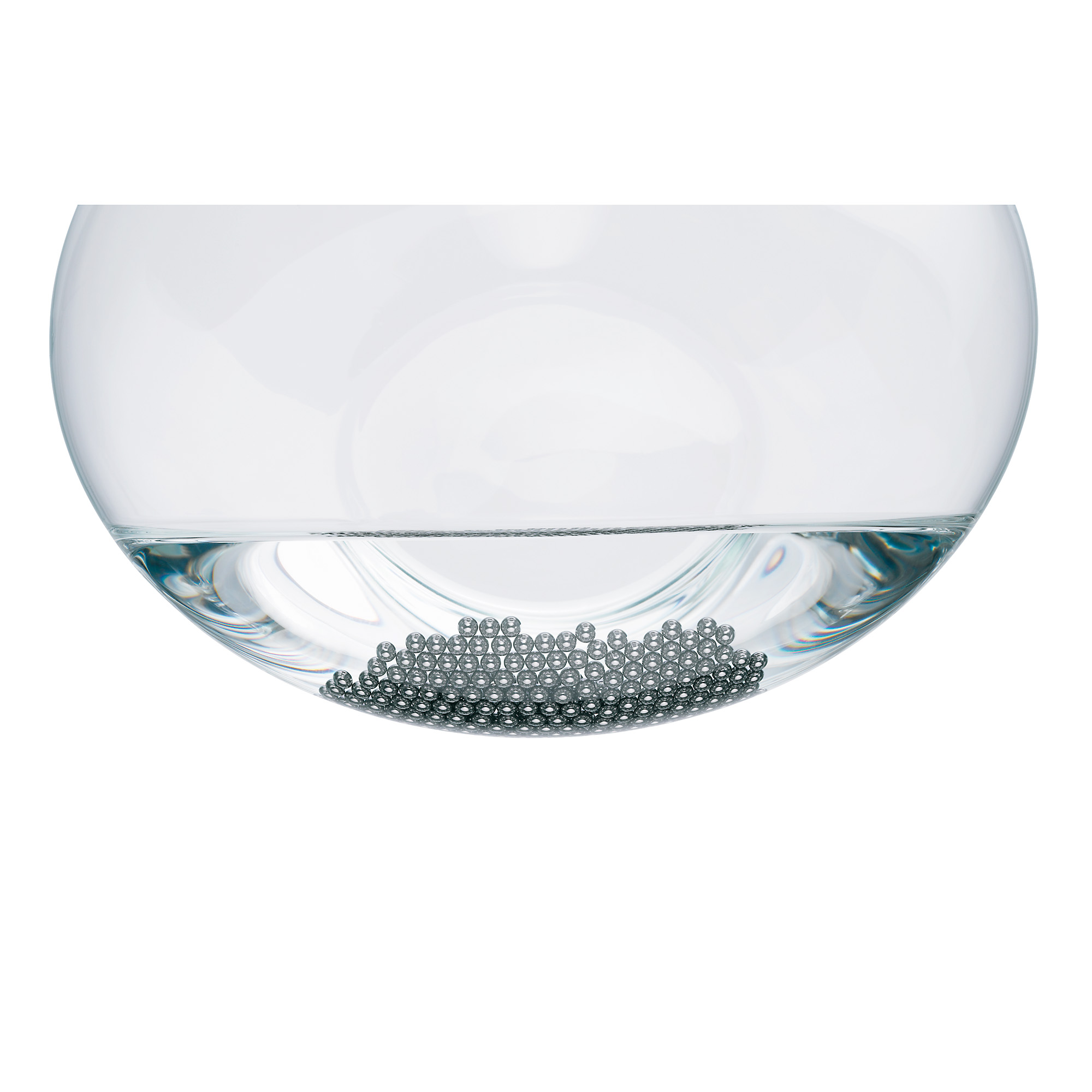 Eine Glasschale gefüllt mit Wasser und kleinen silbernen Kügelchen am Boden.