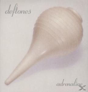 Cremefarbenes medizinisches Gerät. Text: Deftones.
