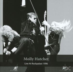 Schwarz-Weiß-Foto der Band Molly Hatchet, die auf der Bühne mit einer Gitarre auftritt.