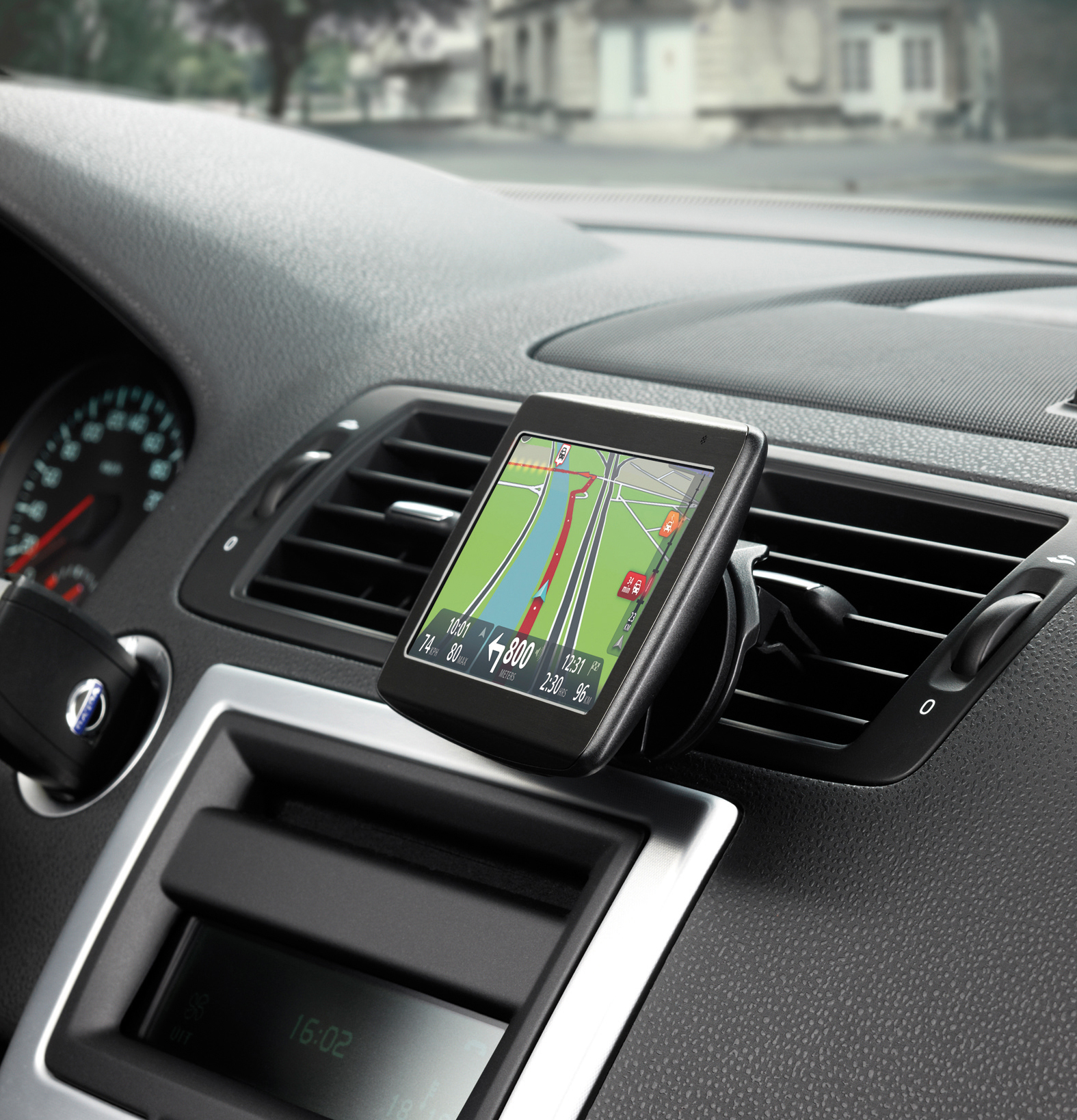 Ein GPS-Gerät im Auto montiert. Der Bildschirm zeigt eine Karte mit grüner Route.