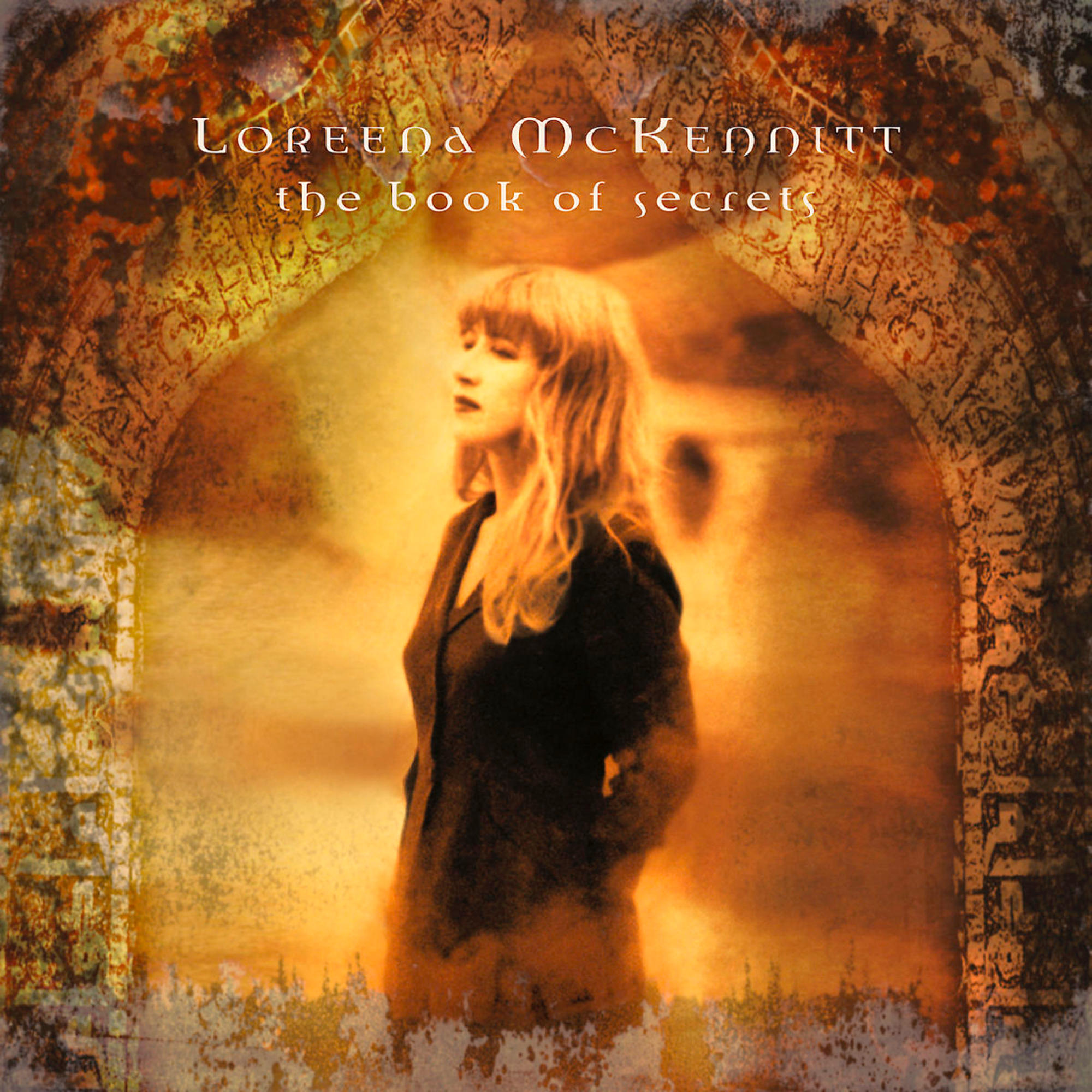 Loreena McKennitt Albumcover. Eine Frau in Schwarz steht in einer gewölbten Steinstruktur.