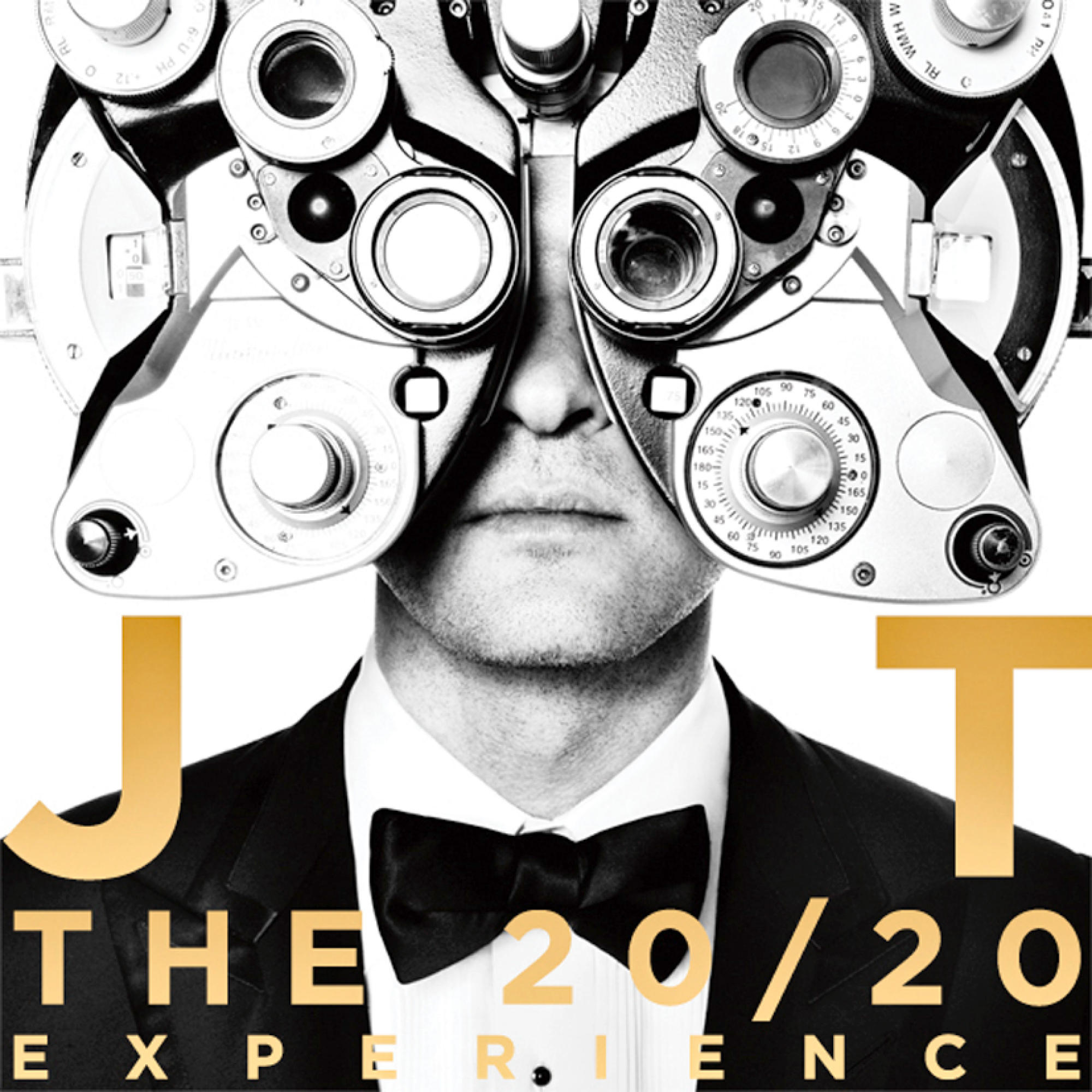Ein Mann mit Smoking und Fliege trägt ein Augenuntersuchungsgerät mit dem Text 'The 20/20 Experience'.