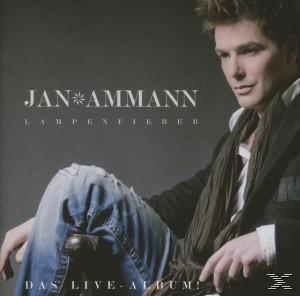 Ein Mann mit dunklen Haaren sitzt mit gekreuzten Beinen; Albumtitel und Künstler oben.