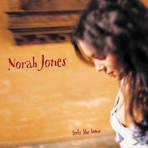 Album borító: Norah Jones, piros szöveg, nő profilban. Barnás-sárga háttér.