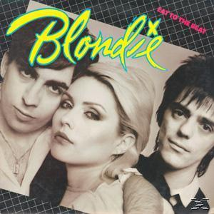 Blondie-Albumcover mit drei Bandmitgliedern vor einem gemusterten Hintergrund.