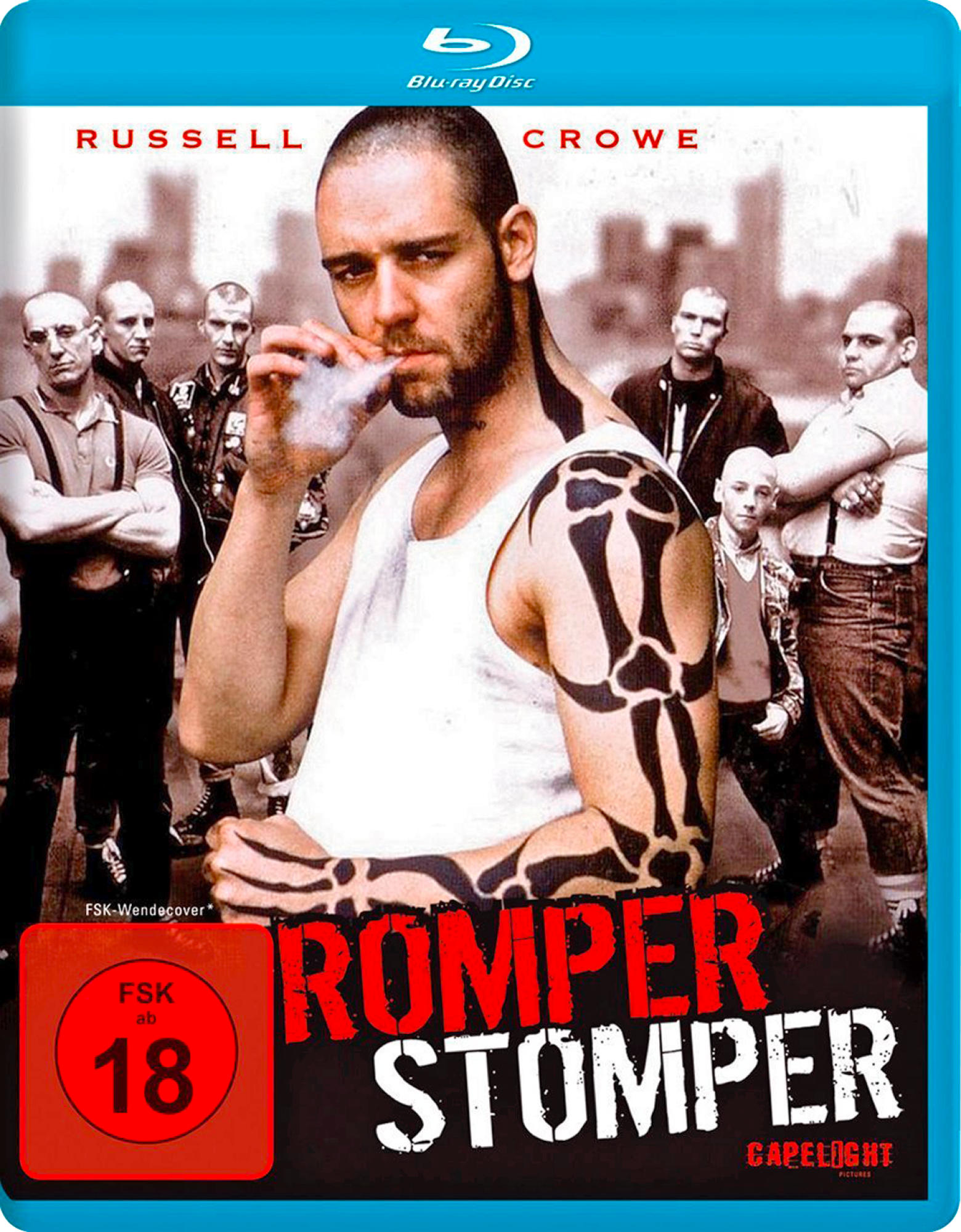 DVD-Cover von Romper Stomper. Mann mit Tattoos raucht, andere Männer im Hintergrund. Rot und blau.