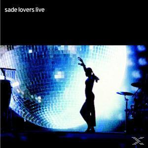 Sade tritt auf der Bühne auf. Silhouette einer Frau mit großem Discokugel-Hintergrund.